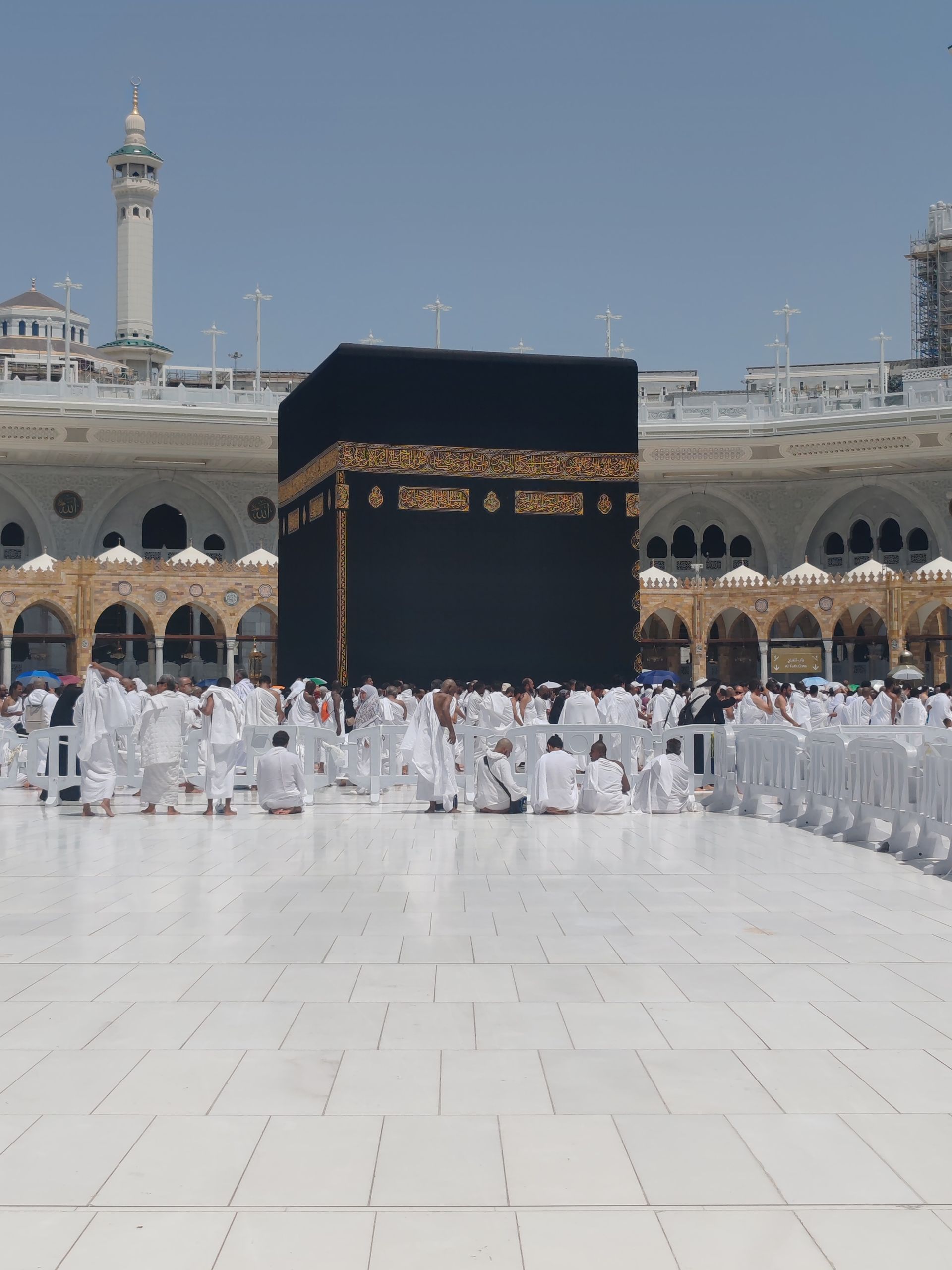 Pilgrims in traditional attire perform rituals around the Kaaba in Mecca, Saudi Arabia.